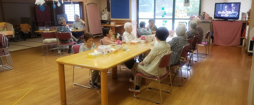 食事中の高齢者入居者たち。共用スペースでの日常風景